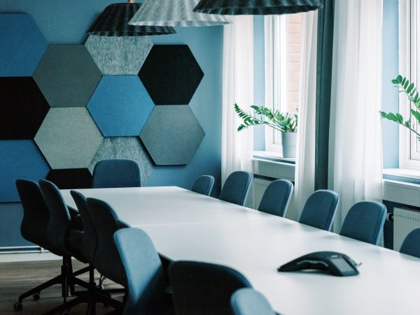 konferensrum, tomt bord med några stolar. färgerna går i mörkblått och grått.
