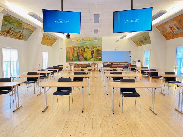 Klassrum med stolar och videoskärmar